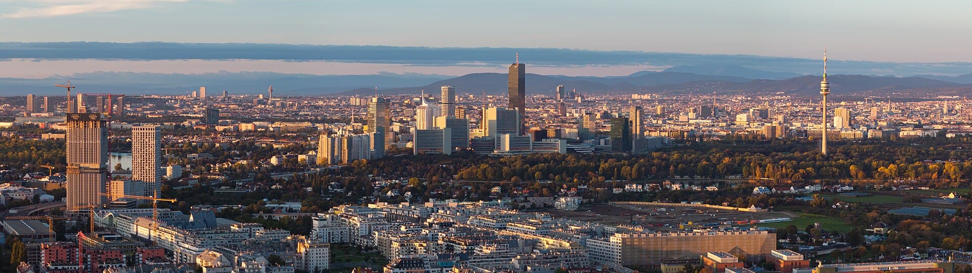 Luftaufnahme der Wiener Skyline mit Donauturm, Hochhäusern der Donau City und Blick über die Stadt Richtung Wienerwald